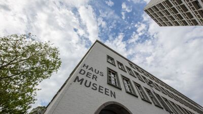 Das Haus der Museen in Olten (4600, Kanton Solothurn) zeigt seine markante Fassade mit grosser Beschriftung unter einem leicht bewoelkten Himmel.