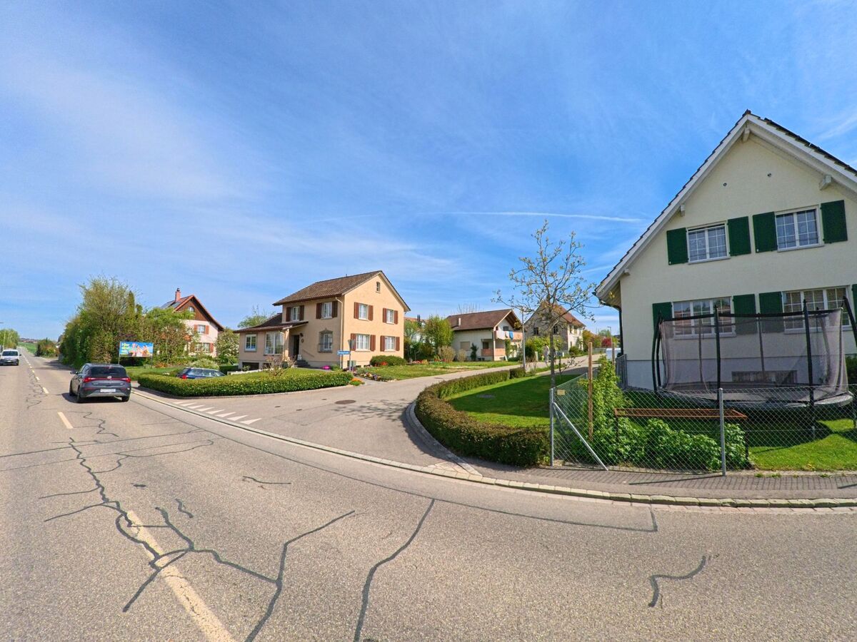 In Henggart, PLZ 8444 im Kanton Zürich, reihen sich entlang einer Hauptstrasse gepflegte Einfamilienhäuser mit Vorgärten und Einfahrten in ruhiger Wohnlage.