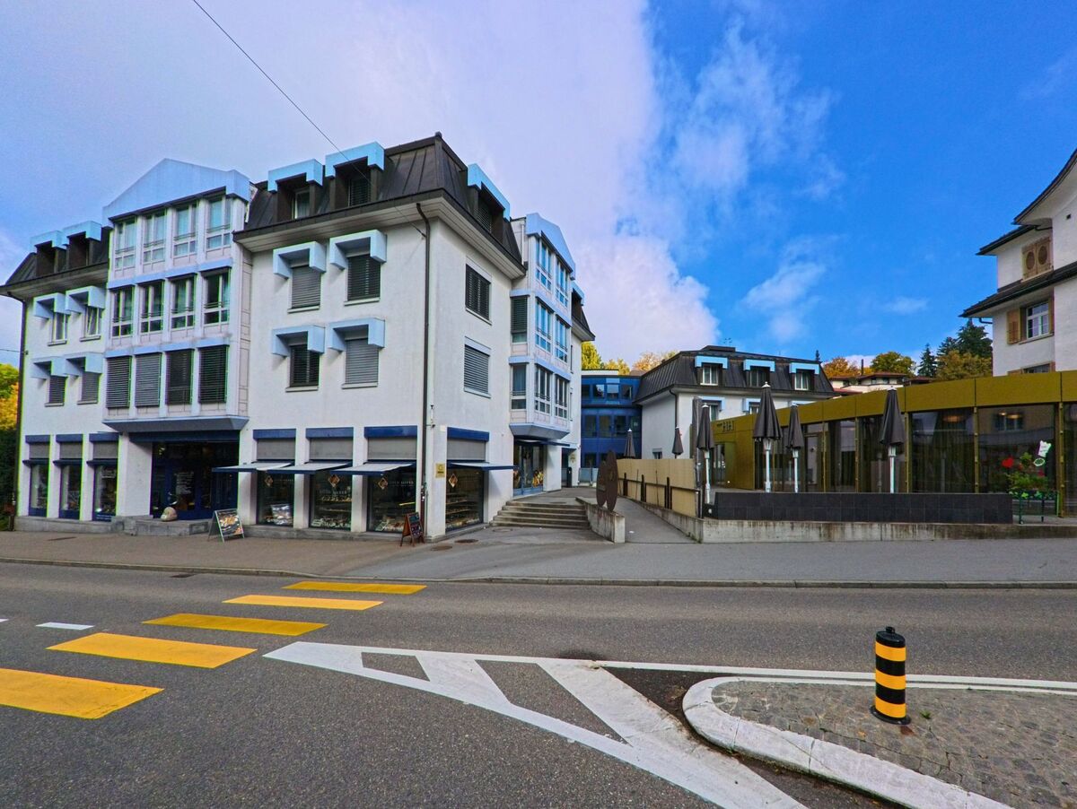 Ein moderner Bau mit klarer Fassadengliederung liegt an einer markierten Einmündung in Herisau (9100, Kanton Appenzell Ausserrhoden).