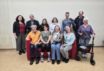 Eine Gruppe von Darstellern posiert gemeinsam in einem Raum vor einer Wand in Herisau (9100, Kanton Appenzell Ausserrhoden) und zeigt ein Theaterensemble.