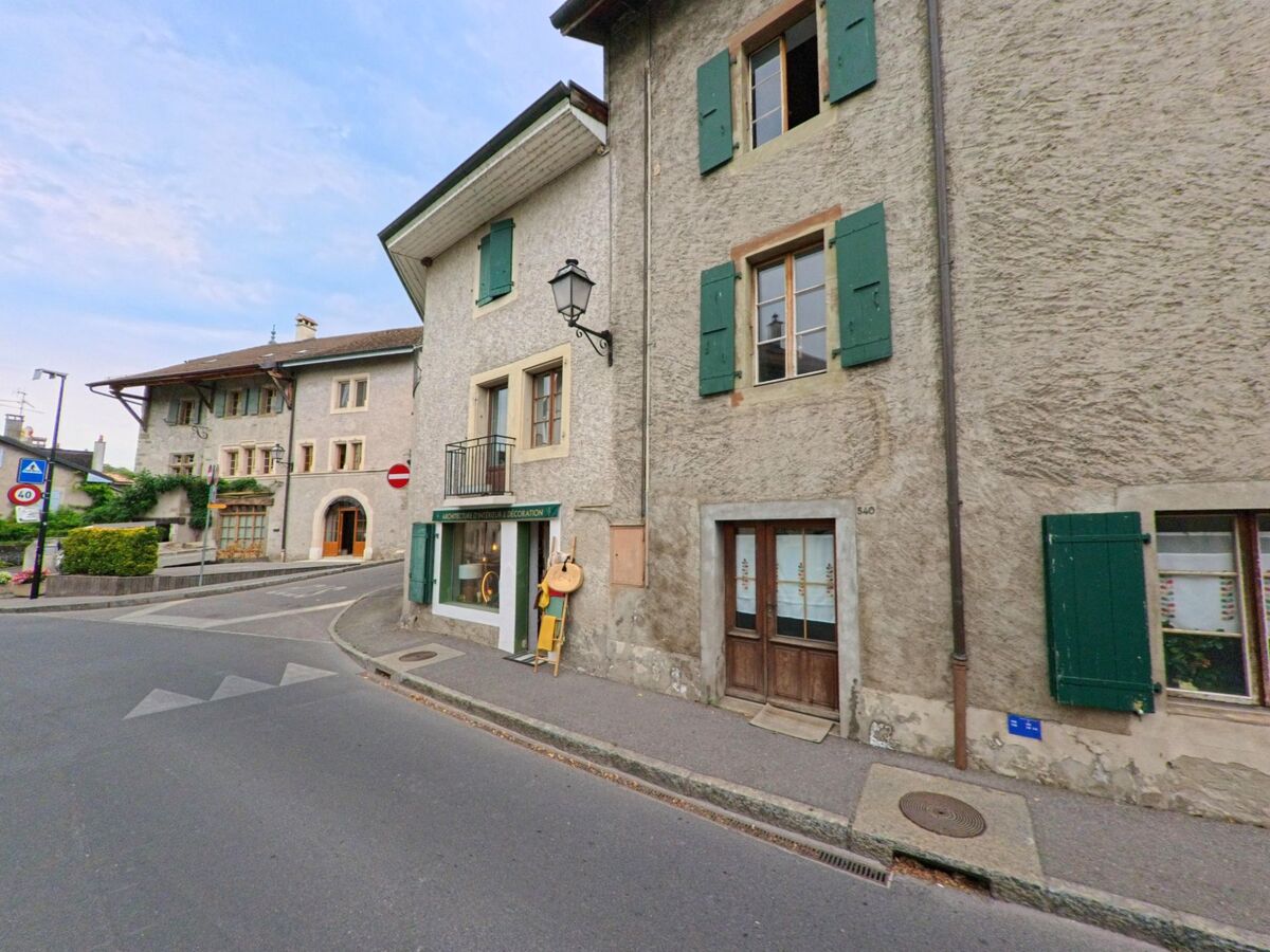 In Hermance (1248, Kanton Genf) befindet sich ein kleines Geschäft im Erdgeschoss eines Hauses mit grünen Fensterläden an der Strasse.