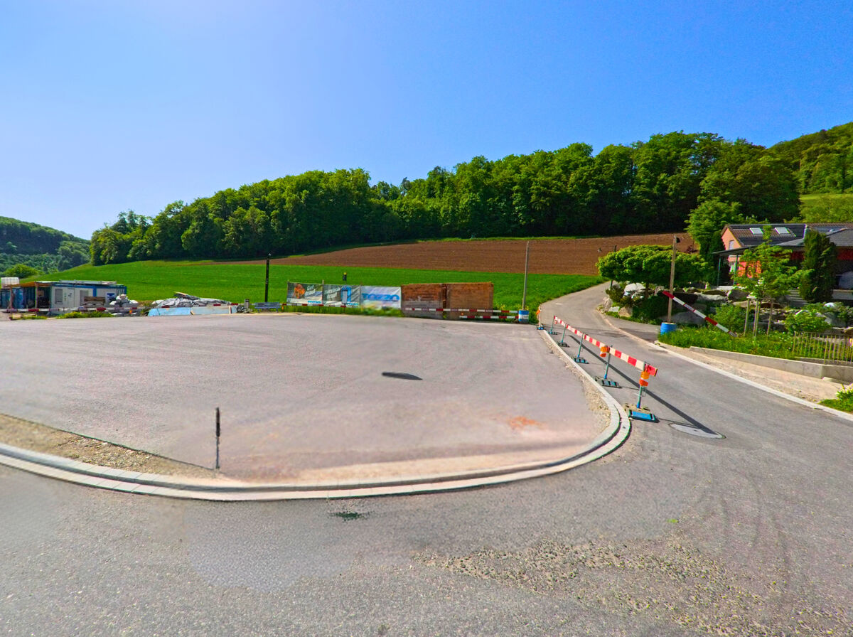 In Hersberg (4423, Kanton Baselland) ist eine Baustelle an einer neuen Straßenkreuzung zu sehen, mit Baugeräten und Absperrungen im Vordergrund.