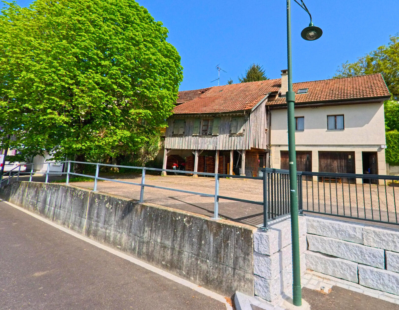 In Hersberg (4423, Kanton Baselland) steht ein grosses Gebäude mit einem gepflegten Garten und einem Parkplatz, umgeben von Bäumen und einem Metallzaun.