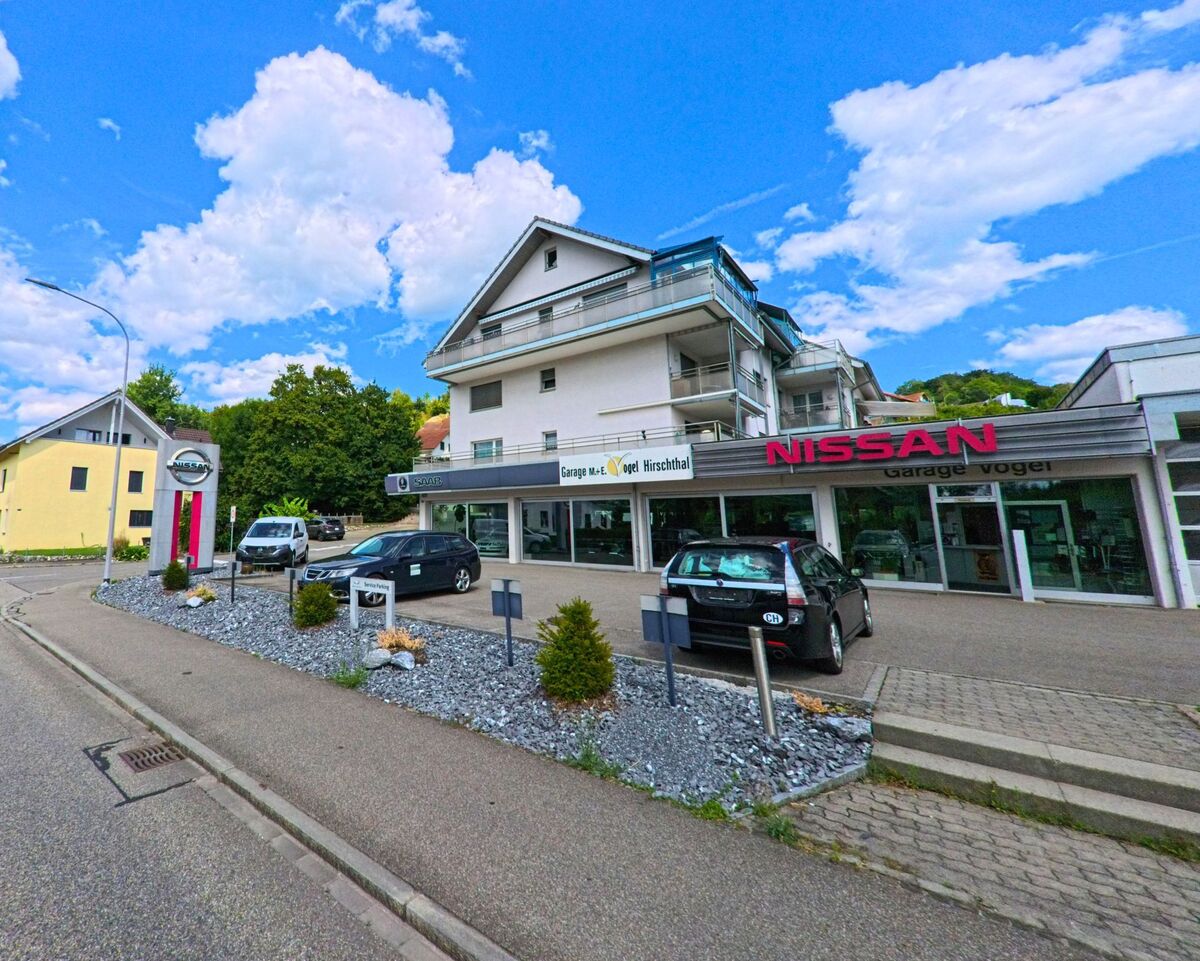 In Hirschthal (5042, Kanton Aargau) befindet sich eine Nissan-Garage mit Verkaufsflaeche und mehreren ausgestellten Fahrzeugen direkt an einer Einfahrtsstrasse.