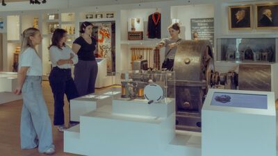 Im Historischen Museum Baden in Baden (5400, Kanton Aargau) betrachten Besucher eine Fuehrung zu technischen Exponaten in einem hellen Ausstellungsraum.