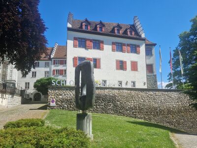In Arbon (9320, Kanton Thurgau) erhebt sich das historische Schloss Arbon mit weisser Fassade und roten Fensterlaeden, heute Sitz des Historischen Museums.