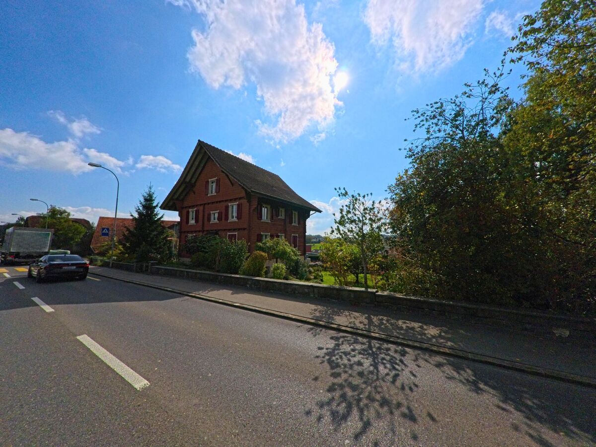 Ein traditionelles Wohnhaus mit Holzfassade liegt an einer ruhigen Strasse in Hochdorf (6280, Kanton Luzern).