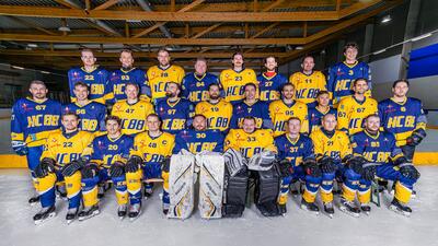 Das Team des Hockeyclub 88 Baar posiert in der Eishalle in Baar (6312, Kanton Zug) in gelb-blauen Trikots für ein Gruppenfoto auf dem Eis.