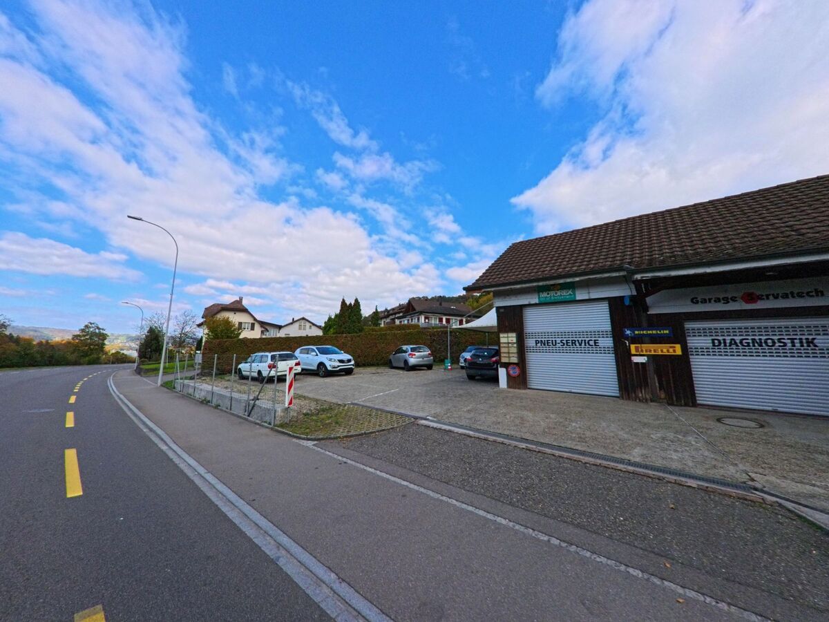 An einer leicht gekruemmten Strasse in Holderbank (5113, Kanton Aargau) befindet sich eine Autowerkstatt mit Pneu-Service und Diagnostikbereich.