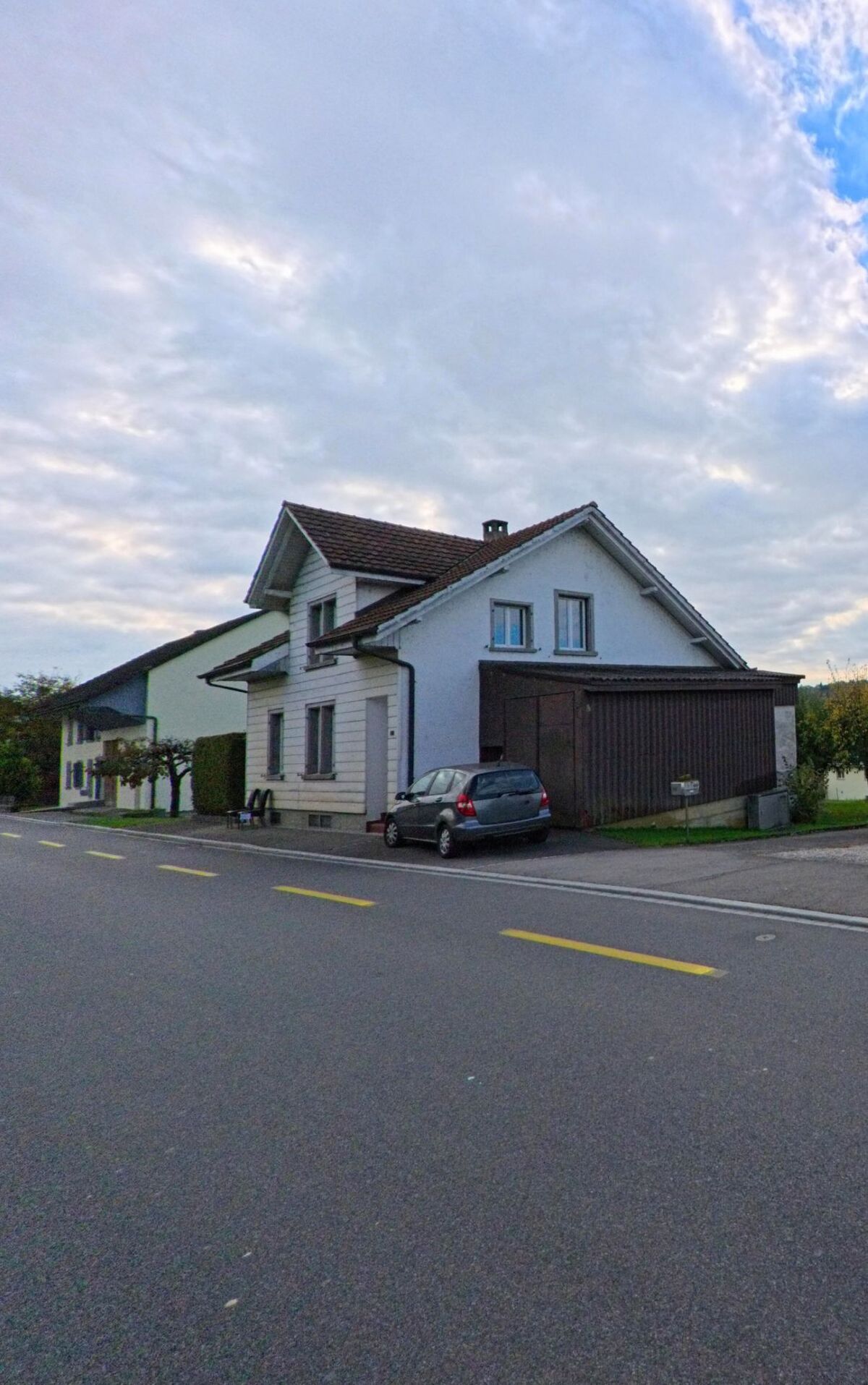 Ein helles Wohnhaus mit angebauter Garage steht direkt an der Hauptstrasse in Holderbank (5113, Kanton Aargau).