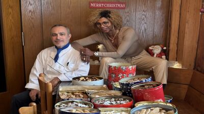 Im Hotel Linde Goldach in Goldach (9403, Kanton St. Gallen) sitzen zwei Personen neben festlich dekorierten Blechdosen voller Weihnachtsgebaeck.