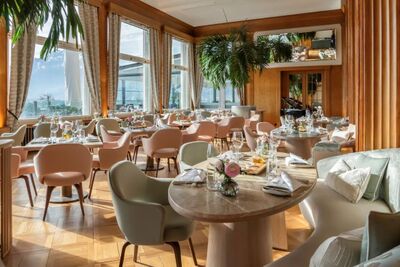 Das Restaurant im Hotel Montana in Luzern (6006, Kanton Luzern) bietet elegant gedeckte Tische mit grossen Fenstern und Blick auf die Berge.