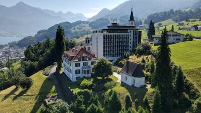 In Quarten (8883, Kanton St. Gallen) liegt das Hotel Neu-Schoenstatt auf einem Huegel mit Blick auf den Walensee, neben einer kleinen Kapelle und umgeben von Bergen.