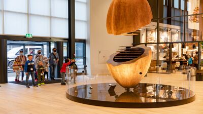 Im House of Laederach in Bilten (8865, Kanton Glarus) betrachten Kinder und Erwachsene eine grosse Skulptur in Form einer Kakaobohne im modernen Besucherzentrum.