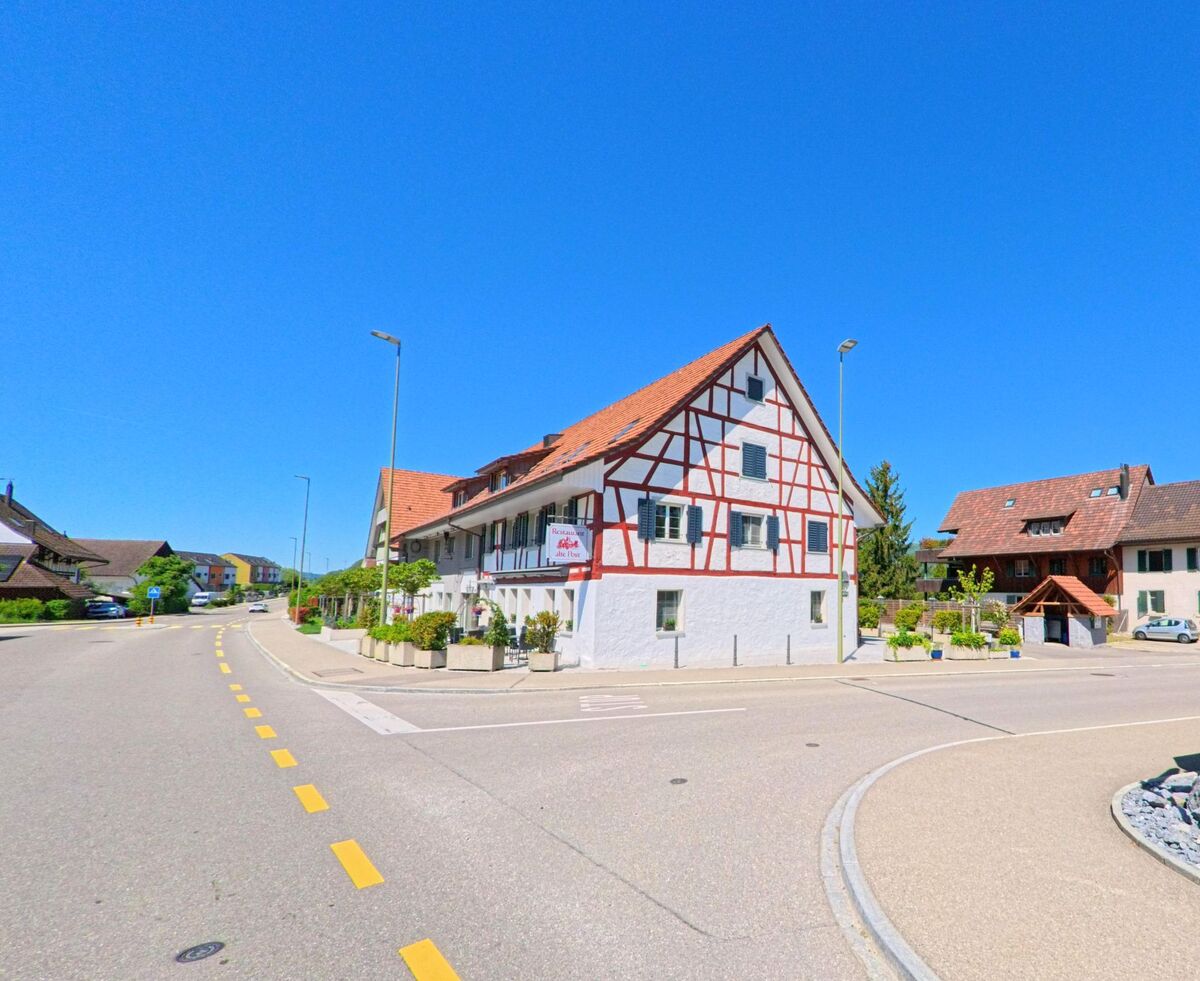 Ein Fachwerkhaus mit Restaurantnutzung steht in Hüttikon im PLZ-Gebiet 8115 im Kanton Zürich an einer zentralen Strassenkreuzung im Dorfkern.