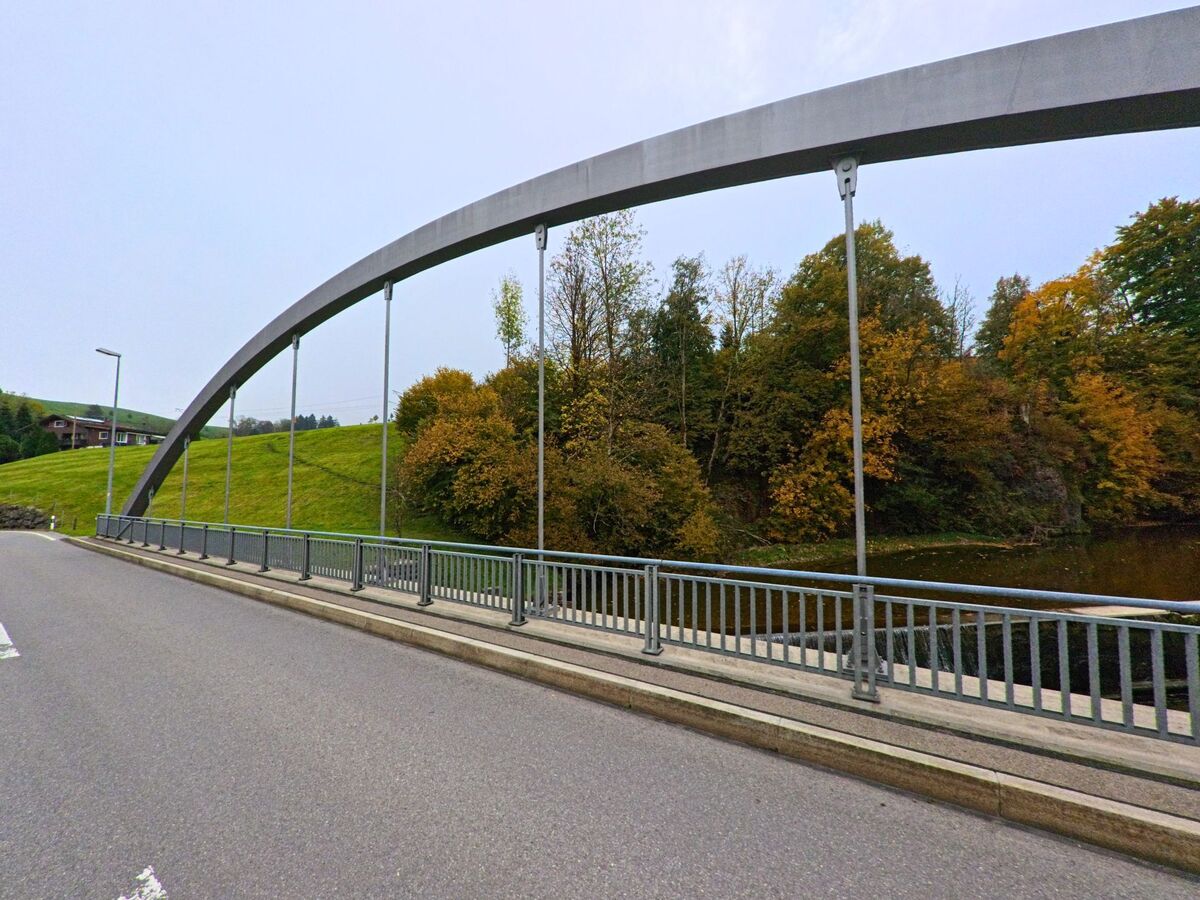 Eine Stahlbogenbrücke überspannt die Strasse am Waldrand von Hundwil (9064, Kanton Appenzell Ausserrhoden).