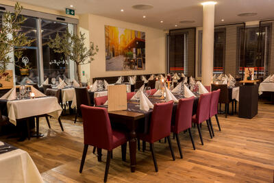 In Eschlikon (8360, Kanton Thurgau) zeigt das Restaurant Il Tiglio einen stilvoll gedeckten Gastraum mit roten Stuehlen, Kerzenlicht und mediterraner Atmosphaere.