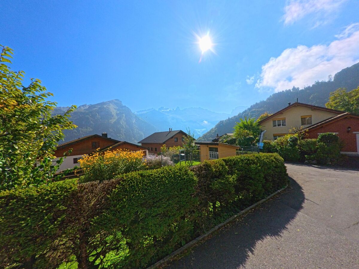 Zwischen Hecken und Wohnhäusern verläuft eine Quartierstrasse in Illgau (6434, Kanton Schwyz).