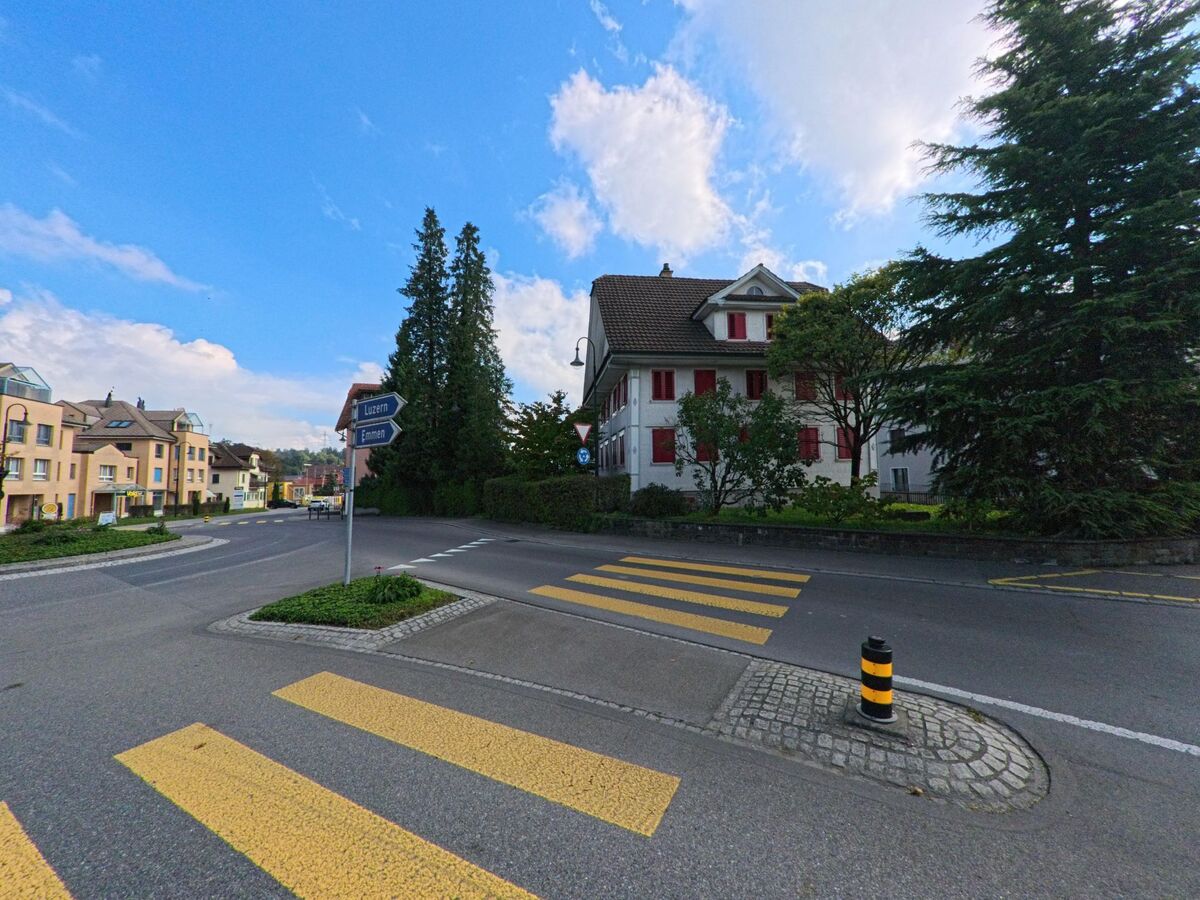 An einer Strassenecke mit Fussgängerstreifen zeigt sich eine übersichtliche Verkehrssituation in Inwil (6034, Kanton Luzern).