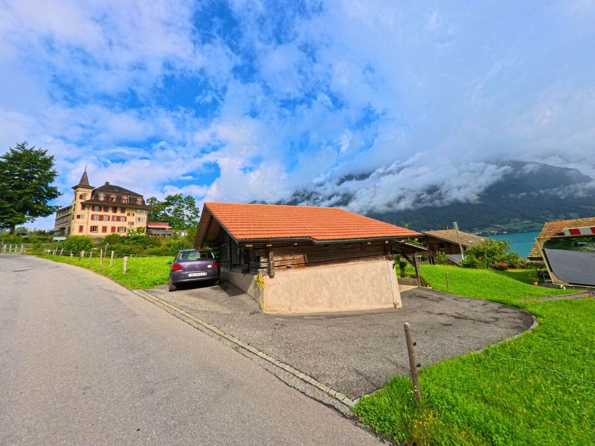 In Iseltwald (3807, Kanton Bern) steht oberhalb des Brienzersees ein herrschaftliches Gebäude mit Turm neben schlichten Nebengebäuden und einer Panoramasicht auf die umliegenden Berge.