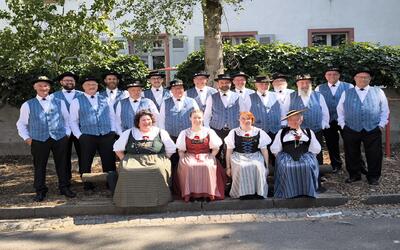Der Jodlerklub vom Studenland posiert in Schneisingen (5425, Kanton Aargau) in traditioneller Tracht für ein gemeinsames Gruppenfoto im Freien.