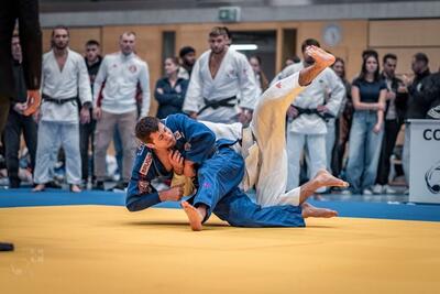 In Zürich (8049, Kanton Zürich) fuehren zwei Judoka in einer Sporthalle einen Wurf auf der Wettkampfmatte aus.
