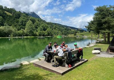 Eine Gruppe Jugendlicher sitzt an einem Picknicktisch am Seeufer in Weinfelden (8570, Kanton Thurgau) und geniesst eine Pause in der Natur.