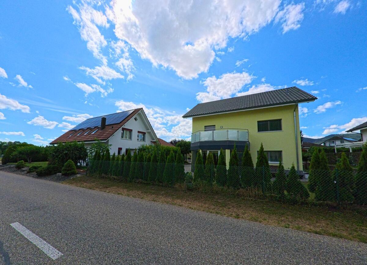 Zwei Einfamilienhäuser mit gepflegten Vorgärten und Solarpanelen auf dem Dach stehen in Kappel (PLZ 4616, Kanton Solothurn) entlang einer ruhigen Quartierstrasse.