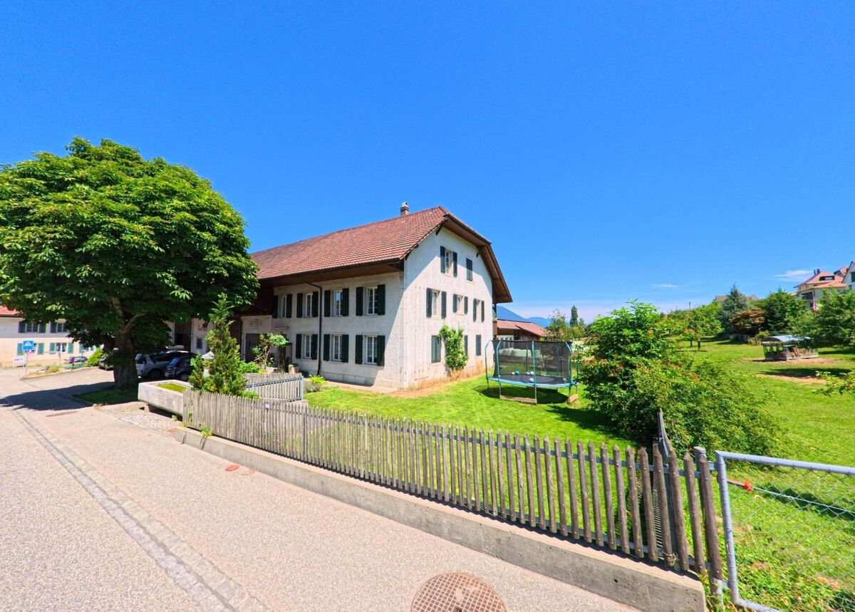 In Kestenholz (4703, Kanton Solothurn) steht ein traditionelles Wohnhaus mit Fensterläden neben einem grosszügigen Garten mit Trampolin und Obstbäumen.