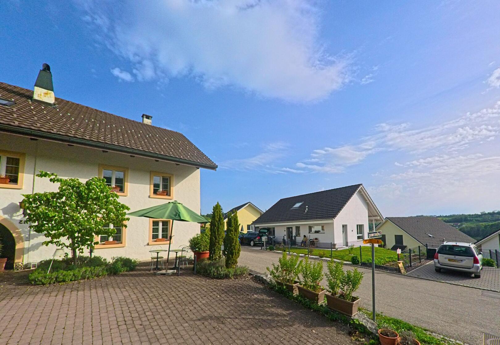 In einem Wohnquartier von Kienberg (4468, Kanton Solothurn) stehen moderne Einfamilienhäuser entlang einer ruhigen Strasse mit Blick ins Grüne.