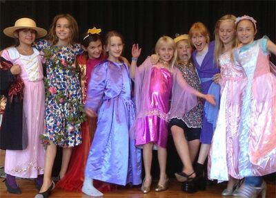 Verkleidete Kinder stehen lachend in bunten Kostuemen auf einer Buehne in Schaffhausen (8200, Kanton Schaffhausen) waehrend einer Theaterauffuehrung.