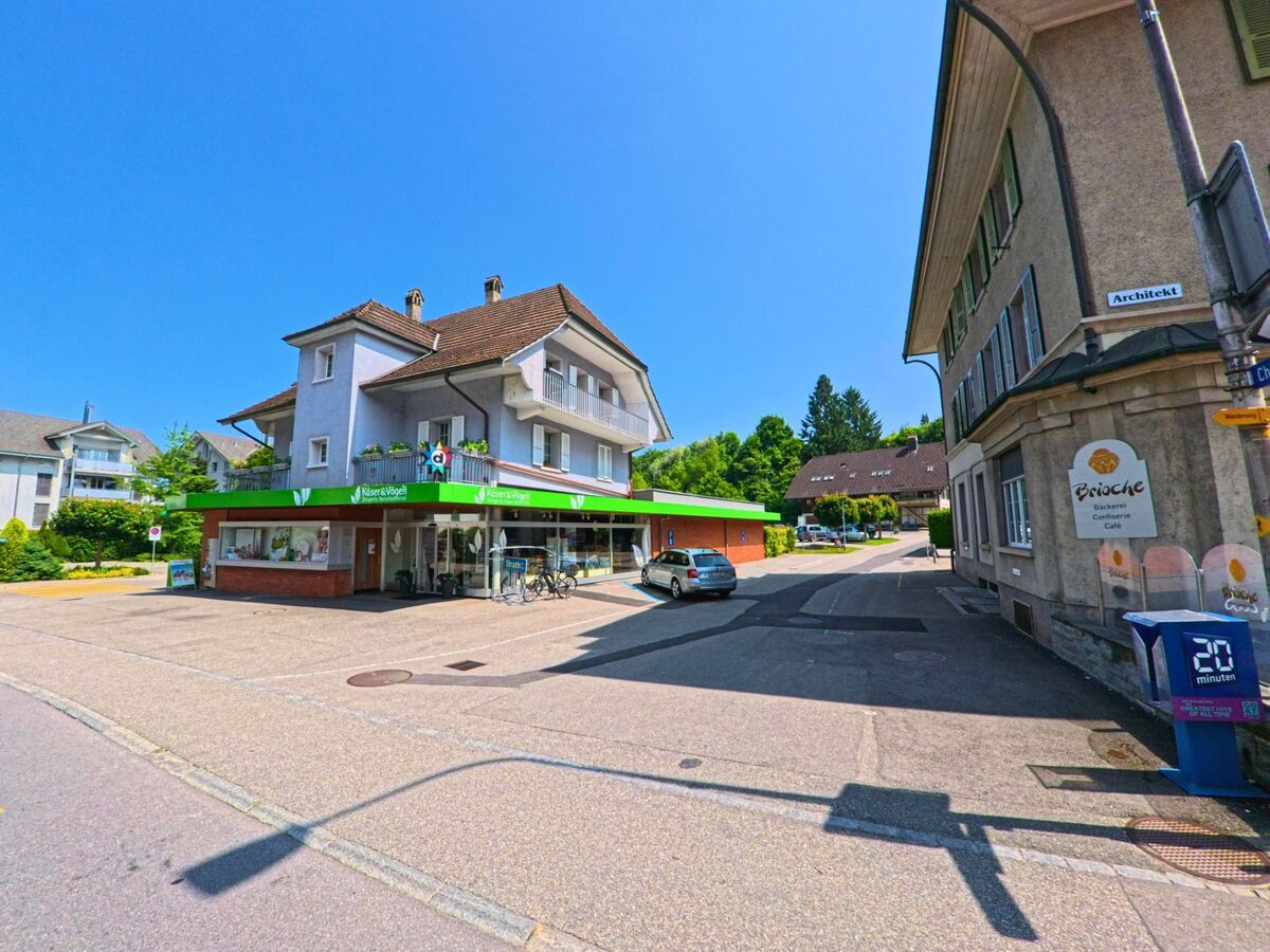 Im Zentrum von Kirchberg (3422, Kanton Bern) befindet sich ein Lebensmittelgeschäft mit grüner Markise an der Ecke zweier Quartierstrassen.
