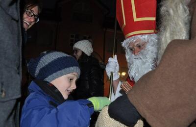 Bei der Klausaktion Widnau begegnet ein Kind einer als Samichlaus verkleideten Person und greift in einen Jutesack in Widnau (9443, Kanton St. Gallen).
