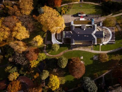 Im Kurpark von Baden (5400, Kanton Aargau) liegt ein grosses Gebäude, umgeben von herbstlich gefärbten Bäumen und geschwungenen Spazierwegen.