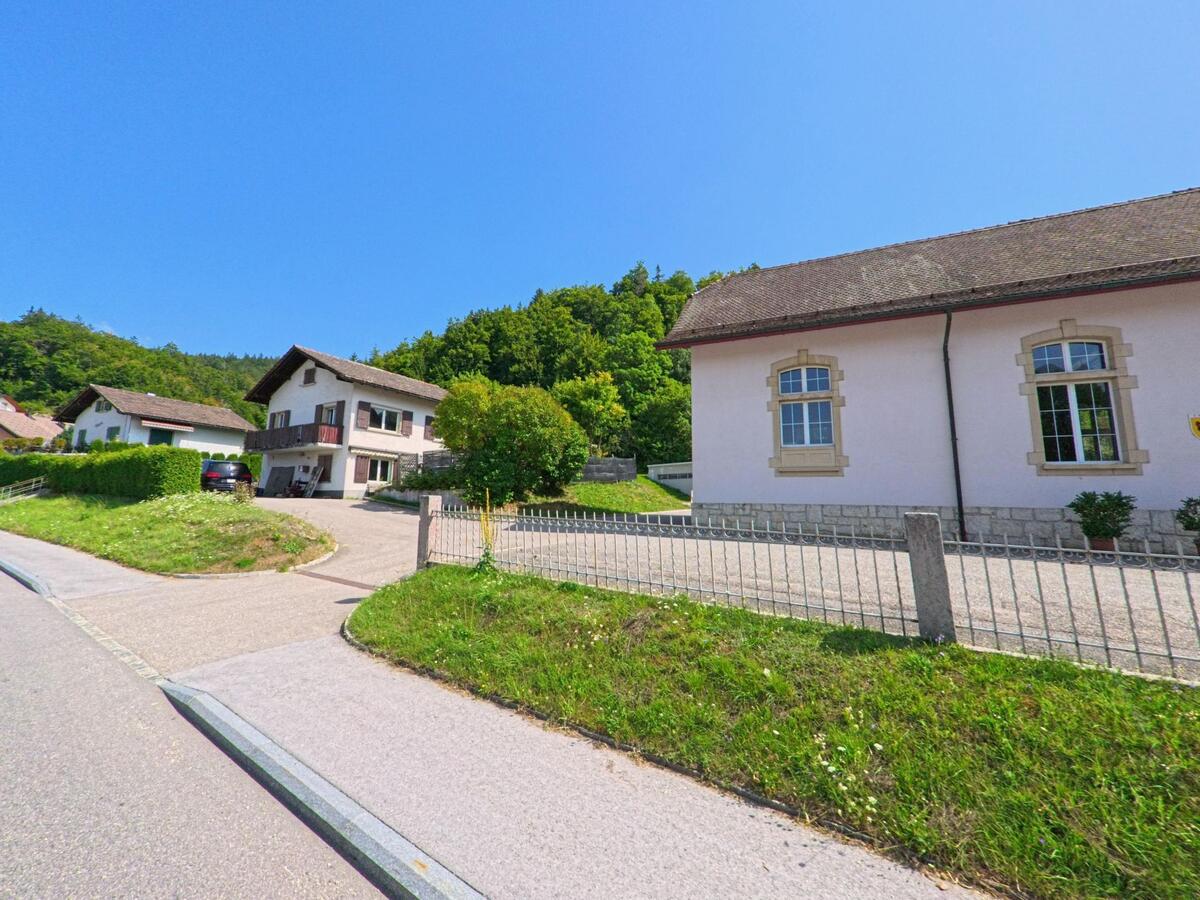 An einer Nebenstrasse in L'Abbaye (1344, Kanton Waadt) stehen Wohnhaeuser und das Gemeindegebaeude, wo ein Kammerjaeger im Einsatz ist.
