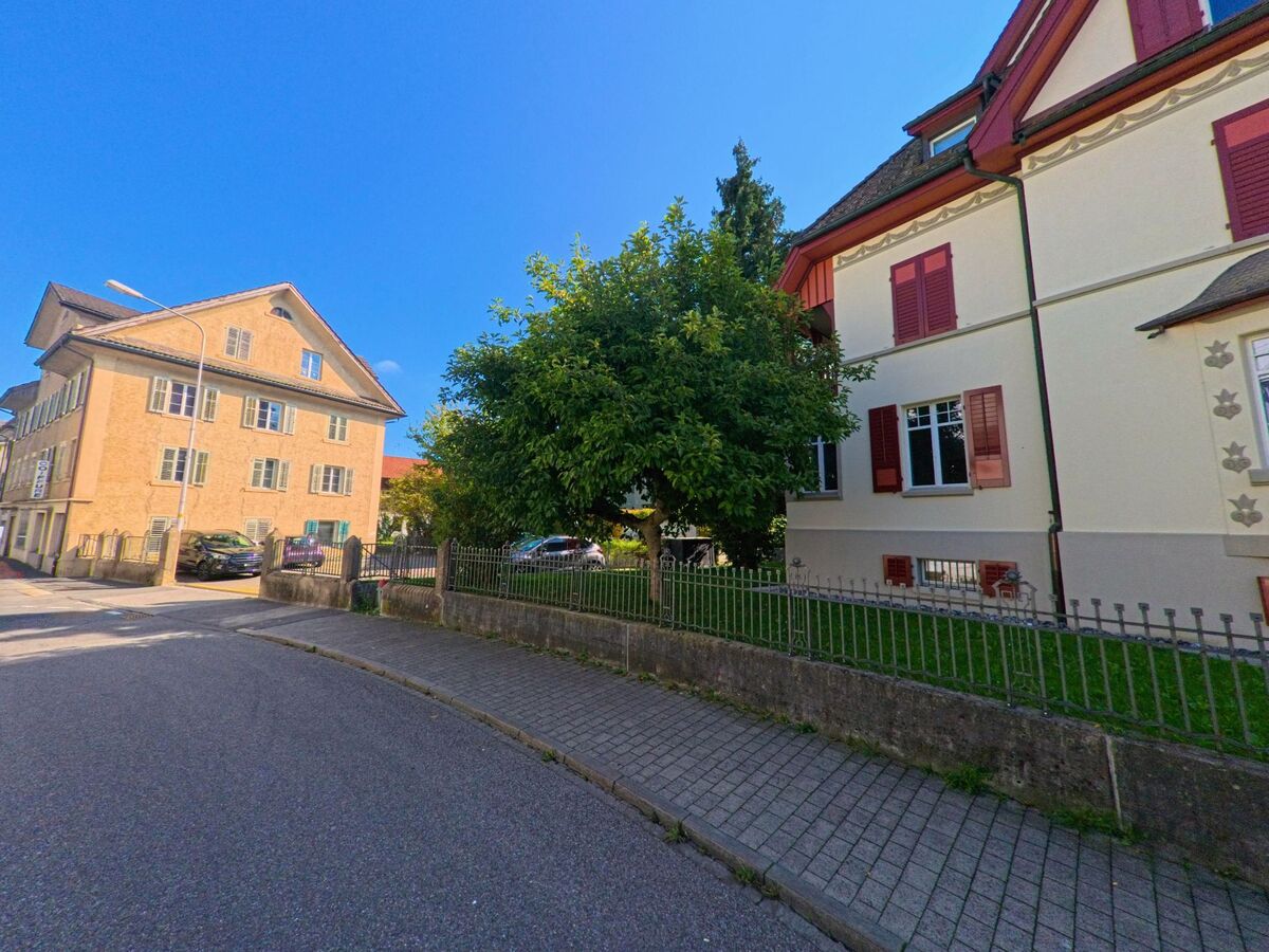 Ein historisches Wohnhaus mit Garten grenzt an einen Gehweg in Lachen (8853, Kanton Schwyz).