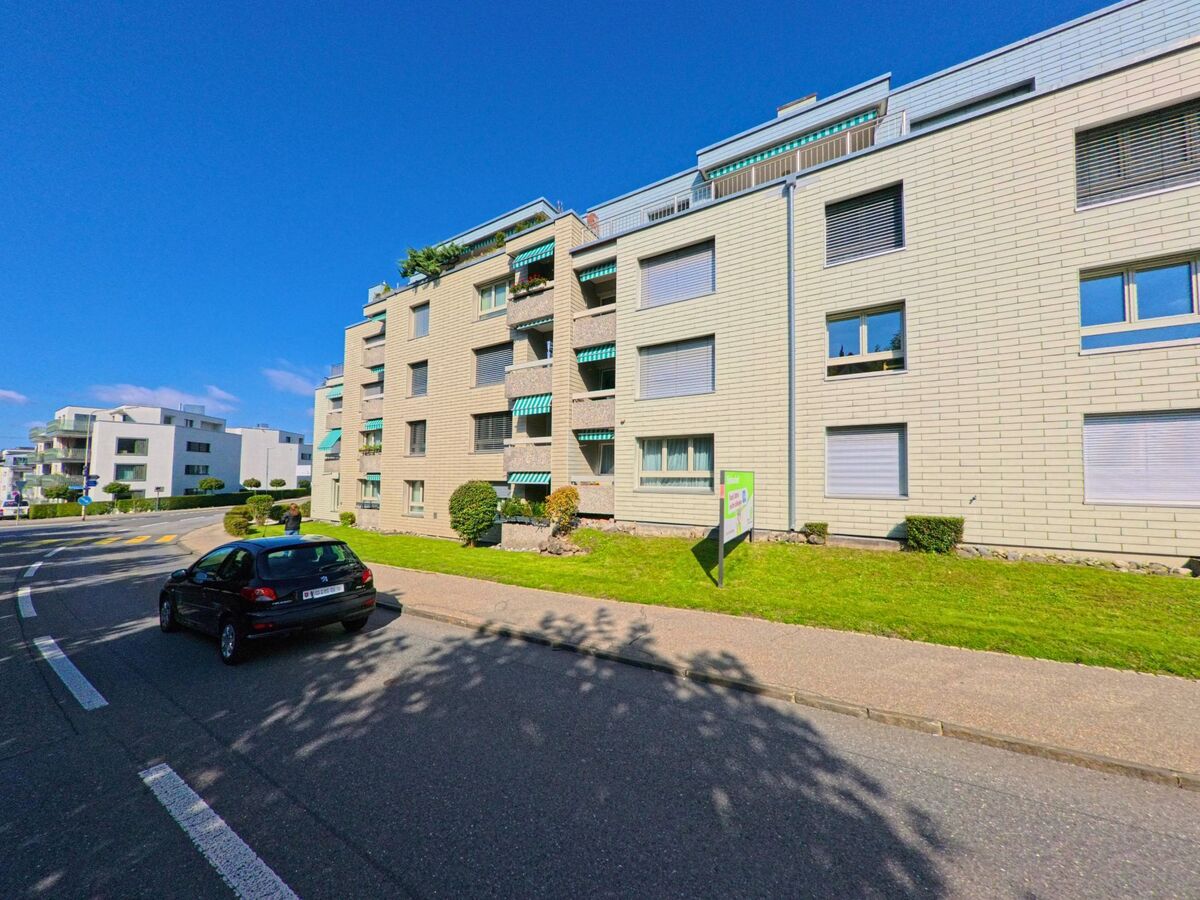 Moderne Wohnhäuser mit Balkonen stehen an einer begrünten Strasse in Lachen (8853, Kanton Schwyz).