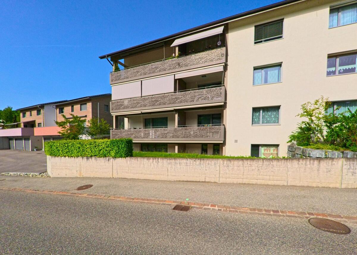 Mehrfamilienhäuser mit Balkonen und gepflegtem Vorplatz prägen das moderne Wohnquartier in Läufelfingen (4448, Kanton Baselland).