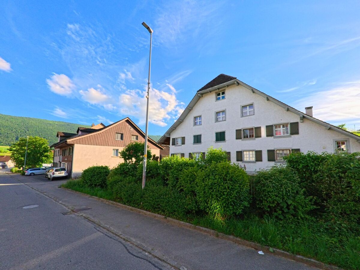 In Laupersdorf (4712, Kanton Solothurn) steht ein grosses Wohnhaus mit typischem Satteldach und Fensterläden an einer ruhigen Strasse mit Blick auf die Hügel.