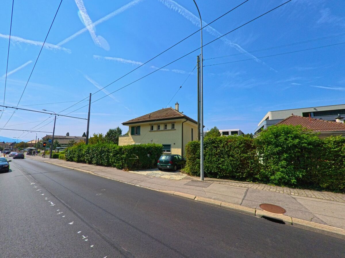 Ein einzelnes Wohnhaus mit Garageneinfahrt liegt in Le Mont-sur-Lausanne (1052, Kanton Waadt) direkt an einer Strasse mit Trolleybusleitungen.
