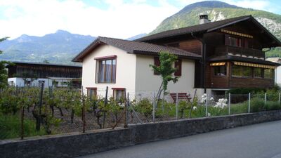 Das Le Relais du Château in Aigle (1860, Kanton Waadt) befindet sich in einem charmanten Haus mit Holzfassade und Blick auf die umliegenden Berge und Weinreben.