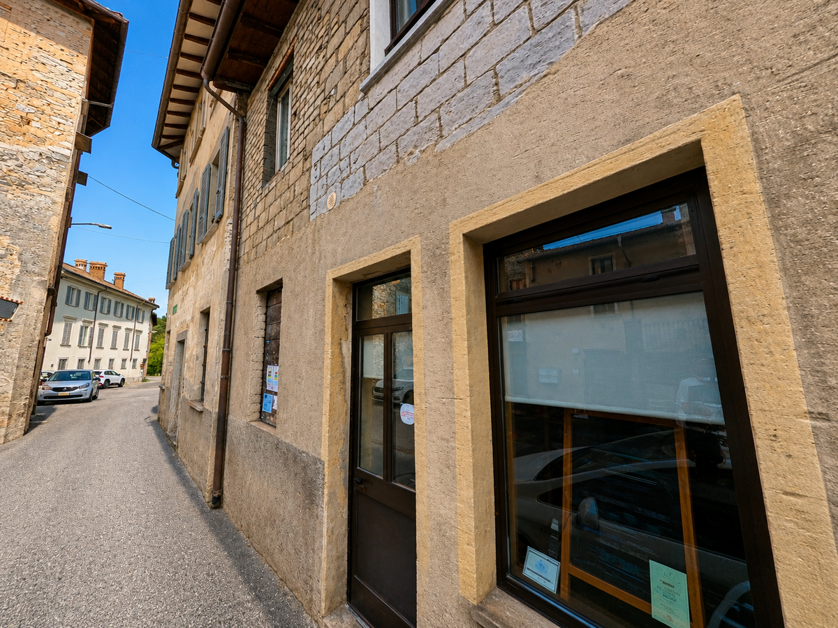 Durch den historischen Dorfkern von Lema (6997, Kanton Tessin) führt eine enge Gasse zwischen alten Stein- und Putzfassaden mit grossen Fenstern.