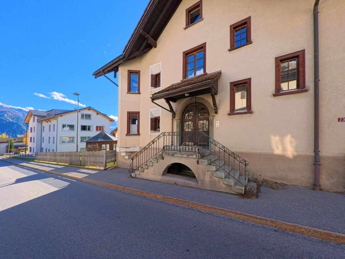 Ein historisch wirkendes Wohnhaus mit steinerner Eingangstreppe prägt eine ruhige Seitenstrasse in Lenz (7083, Kanton Graubünden).