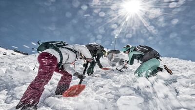Bei strahlendem Sonnenschein üben Mitglieder der Les Guides de Verbier in Verbier (1936, Kanton Wallis) den Einsatz von Lawinenschaufeln im Schnee als Teil einer alpinen Rettungssimulation.