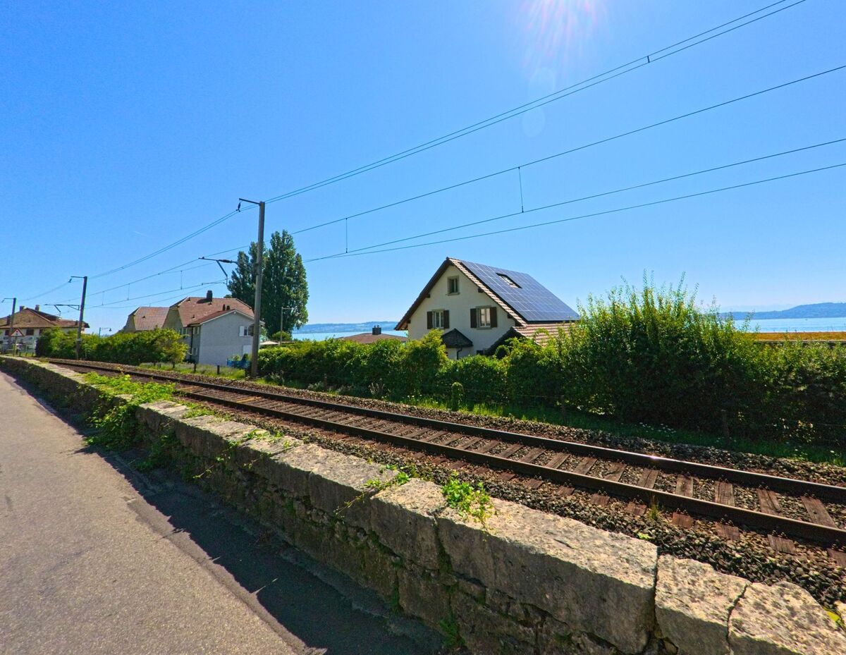 Entlang der Bahnstrecke in Ligerz (2514, Kanton Bern) stehen Wohnhaeuser mit Blick auf den Bielersee.