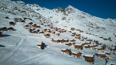In Wiler (3918, Kanton Wallis) liegen zahlreiche Chalets der Lauchernalp eingebettet in eine verschneite Winterlandschaft am Hang oberhalb des Lötschentals.