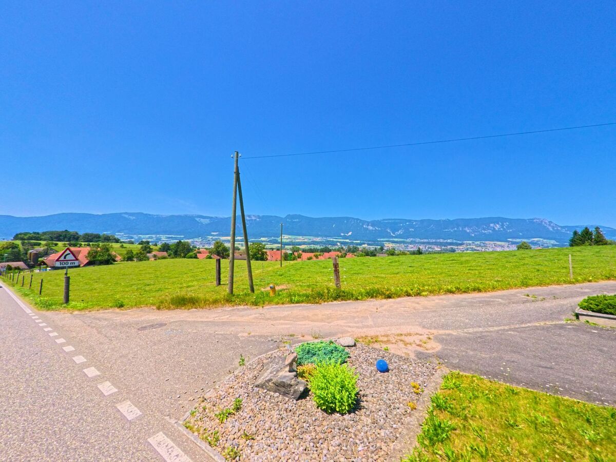 Von Lüsslingen-Nennigkofen (4574, Kanton Solothurn) bietet sich ein weiter Blick über grüne Felder hinweg bis zum Jura mit der Stadt Solothurn im Hintergrund.