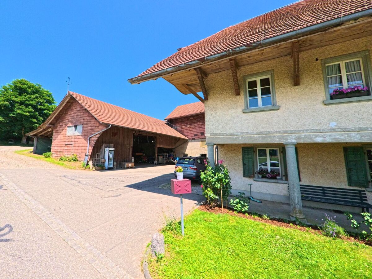 Ein Bauernhaus mit angrenzender Scheune und kleinem Hofbereich steht in Lüterkofen-Ichertswil (4571, Kanton Solothurn) an einer Nebenstrasse im Grünen.