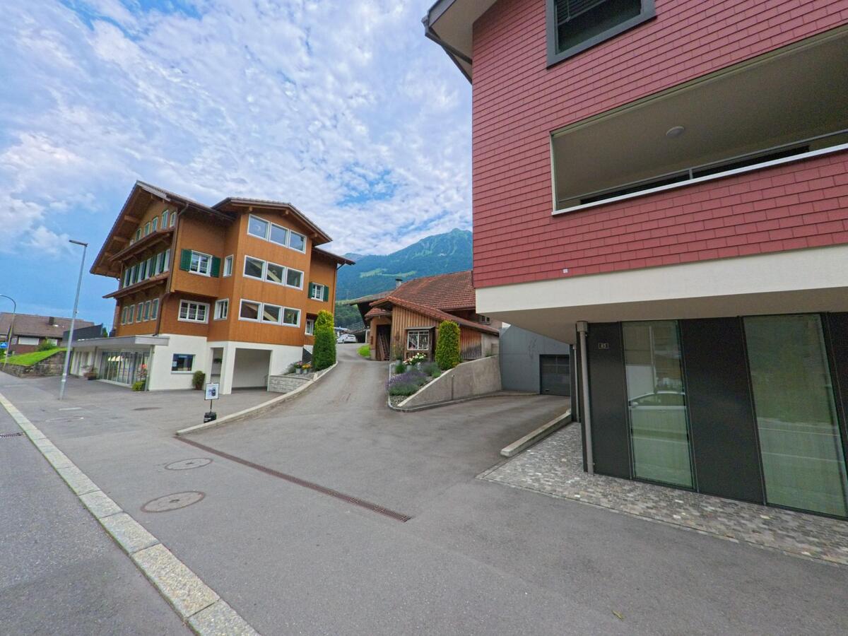 In Lungern (6078, Kanton Obwalden) prägen moderne und traditionelle Wohnhäuser mit Holzfassaden das Bild einer ruhigen Seitenstrasse am Hang.