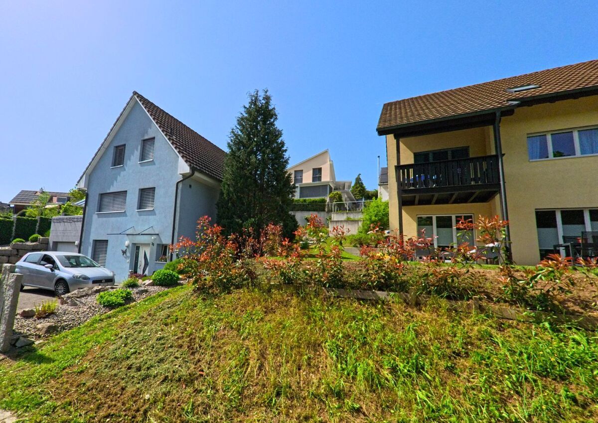 In Lupsingen (PLZ 4419, Kanton Basel-Landschaft) säumen gepflegte Einfamilienhäuser und bepflanzte Vorgärten eine ruhige Hanglage.